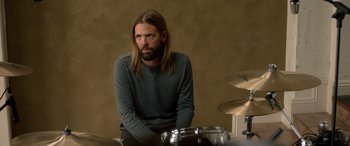 Movie still from “Studio 666” (2022), directed by BJ McDonnell – A man sitting in front of a drum set; Close Up shot, High angle