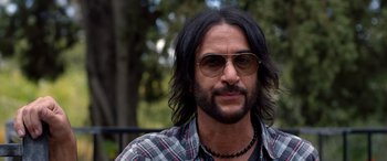 Movie still from “Studio 666” (2022), directed by BJ McDonnell – A person wearing sunglasses and a plaid shirt; Close Up shot, Over the shoulder angle