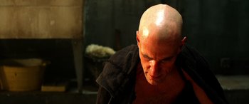 Movie still from “Studio 666” (2022), directed by BJ McDonnell – A bald man with a shaved head looking down at the ground; Close Up shot, Low angle