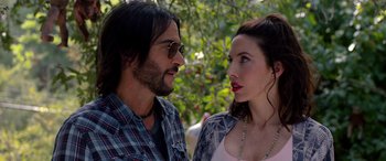 Movie still from “Studio 666” (2022), directed by BJ McDonnell – A man and a woman standing next to each other in front of trees; Close Up shot, Over the shoulder angle