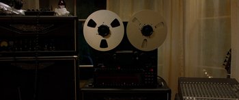 Movie still from “Studio 666” (2022), directed by BJ McDonnell – A pair of reels sitting on top of an analog tape recorder; Extreme Close Up shot, Low angle