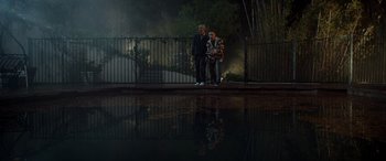 Movie still from “Studio 666” (2022), directed by BJ McDonnell – A man and a woman standing next to each other near a pond; Wide shot, Low angle