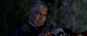 Movie still from “Studio 666” (2022), directed by BJ McDonnell – An older man is holding a camera and looking at the camera; Close Up shot, Over the shoulder angle