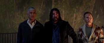 Movie still from “Studio 666” (2022), directed by BJ McDonnell – Two men standing next to each other near a forest; Medium shot, Low angle