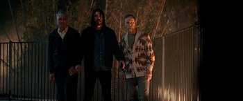 Movie still from “Studio 666” (2022), directed by BJ McDonnell – Two men standing next to each other near a fence; Medium shot, Low angle