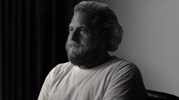 Movie still from “Stutz” (2022), directed by Jonah Hill – Black and white photograph of a man with long hair and a beard; Close Up shot, Low angle
