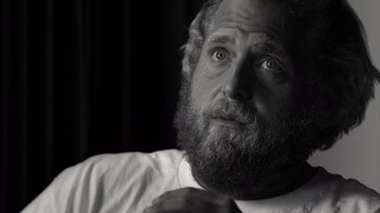 Movie still from “Stutz” (2022), directed by Jonah Hill – Black and white photograph of a man with a beard; Close Up shot, Over the shoulder angle