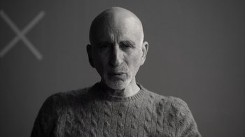 Movie still from “Stutz” (2022), directed by Jonah Hill – An older man wearing a gray sweater with a white beard; Close Up shot, Low angle