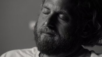 Movie still from “Stutz” (2022), directed by Jonah Hill – Black and white photograph of a man with a beard; Close Up shot, Over the shoulder angle