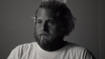 Movie still from “Stutz” (2022), directed by Jonah Hill – Black and white photograph of a man with a beard; Close Up shot, Over the shoulder angle