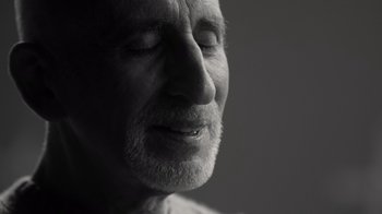 Movie still from “Stutz” (2022), directed by Jonah Hill – An older man with a beard is looking up; Close Up shot, Over the shoulder angle