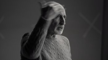 Movie still from “Stutz” (2022), directed by Jonah Hill – An older man wearing a sweater is waving his hand; Close Up shot, Low angle