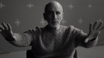 Movie still from “Stutz” (2022), directed by Jonah Hill – An older man wearing a sweater and sitting in a chair; Close Up shot, Low angle