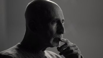 Movie still from “Stutz” (2022), directed by Jonah Hill – An older man with a shaved head is looking at something; Close Up shot, Low angle