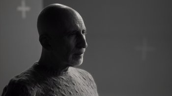 Movie still from “Stutz” (2022), directed by Jonah Hill – An older bald man wearing a sweater looking to his left; Close Up shot, Low angle