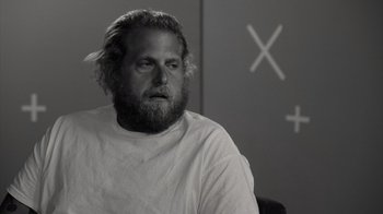 Movie still from “Stutz” (2022), directed by Jonah Hill – Black and white photograph of a man with long hair and a beard; Close Up shot, Over the shoulder angle