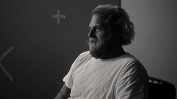 Movie still from “Stutz” (2022), directed by Jonah Hill – Black and white photograph of a man with long hair and a beard; Close Up shot, Over the shoulder angle