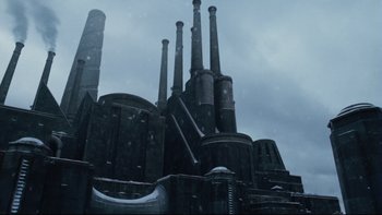 Movie still from “Charlie and the Chocolate Factory” (2005), directed by Tim Burton – A building that has a bunch of pipes on top of it; Extreme Wide shot, Low angle