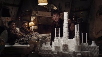 Movie still from “Charlie and the Chocolate Factory” (2005), directed by Tim Burton – A young boy standing in front of a model of a castle; Medium shot, Low angle