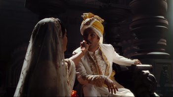 Movie still from “Charlie and the Chocolate Factory” (2005), directed by Tim Burton – A man and a woman in traditional indian garb; Medium shot, Over the shoulder angle