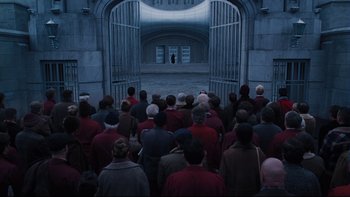 Movie still from “Charlie and the Chocolate Factory” (2005), directed by Tim Burton – A group of people standing in front of an open gate; Extreme Wide shot, High angle