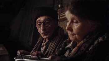 Movie still from “Charlie and the Chocolate Factory” (2005), directed by Tim Burton – An older man and woman sitting next to each other; Close Up shot, Over the shoulder angle