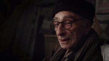 Movie still from “Charlie and the Chocolate Factory” (2005), directed by Tim Burton – An old man wearing glasses and a hat; Close Up shot, Over the shoulder angle