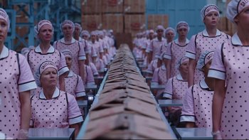 Movie still from “Charlie and the Chocolate Factory” (2005), directed by Tim Burton – A group of women in pink uniforms standing next to a conveyor belt; Wide shot, High angle