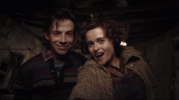 Movie still from “Charlie and the Chocolate Factory” (2005), directed by Tim Burton – A man and a woman posing for a picture; Close Up shot, Overhead angle