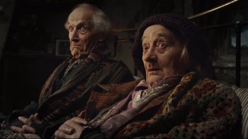 Movie still from “Charlie and the Chocolate Factory” (2005), directed by Tim Burton – Two older people sitting next to each other in a room; Close Up shot, Low angle