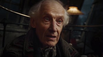 Movie still from “Charlie and the Chocolate Factory” (2005), directed by Tim Burton – An old man with a gray beard and white hair wearing a scarf; Close Up shot, Low angle