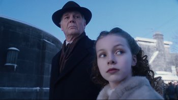 Movie still from “Charlie and the Chocolate Factory” (2005), directed by Tim Burton – An older man and a young girl standing next to each other; Close Up shot, Low angle