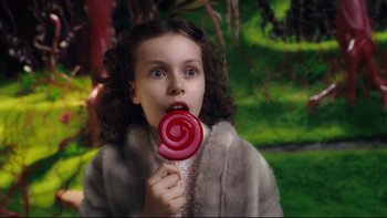 Movie still from “Charlie and the Chocolate Factory” (2005), directed by Tim Burton – A young girl holding a large lollipop in her mouth; Close Up shot, High angle