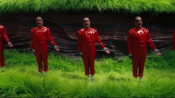 Movie still from “Charlie and the Chocolate Factory” (2005), directed by Tim Burton – A group of people dressed in red standing in the grass; Wide shot, High angle