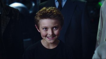 Movie still from “Charlie and the Chocolate Factory” (2005), directed by Tim Burton – A young boy smiling for the camera in front of an older man; Close Up shot, High angle