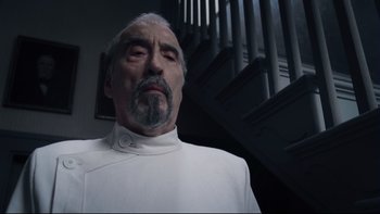 Movie still from “Charlie and the Chocolate Factory” (2005), directed by Tim Burton – An older man in a white shirt is looking at the camera; Medium shot, Low angle