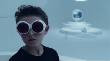 Movie still from “Charlie and the Chocolate Factory” (2005), directed by Tim Burton – A young boy wearing sunglasses in a white room; Close Up shot, Low angle