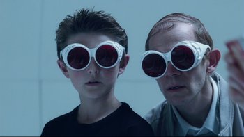Movie still from “Charlie and the Chocolate Factory” (2005), directed by Tim Burton – A man and a boy wearing sunglasses and posing for a picture; Close Up shot, Low angle