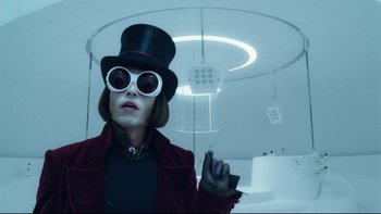 Movie still from “Charlie and the Chocolate Factory” (2005), directed by Tim Burton – A woman wearing a top hat and sunglasses; Medium shot, Low angle