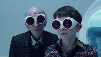 Movie still from “Charlie and the Chocolate Factory” (2005), directed by Tim Burton – A man and a young boy wearing sunglasses; Close Up shot, Over the shoulder angle