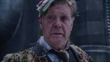 Movie still from “Charlie and the Chocolate Factory” (2005), directed by Tim Burton – An older man wearing a suit and tie with vegetables on his head; Close Up shot, Low angle