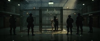 Movie still from “Suicide Squad” (2016), directed by David Ayer – A group of men standing in a jail cell; Wide shot, Low angle