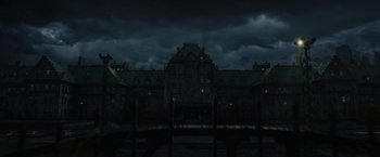 Movie still from “Suicide Squad” (2016), directed by David Ayer – A dark picture of an old building in the dark; Extreme Wide shot, Low angle