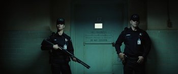 Movie still from “Suicide Squad” (2016), directed by David Ayer – A couple of men standing next to each other holding guns; Wide shot, Low angle