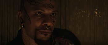 Movie still from “Suicide Squad” (2016), directed by David Ayer – A person with tattoos on their face; Close Up shot, High angle