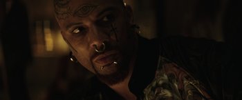 Movie still from “Suicide Squad” (2016), directed by David Ayer – A person with tattoos on their face; Close Up shot, Overhead angle