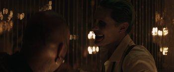 Movie still from “Suicide Squad” (2016), directed by David Ayer – A man with green hair is laughing at another man; Close Up shot, Over the shoulder angle