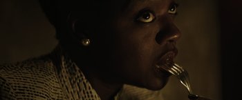 Movie still from “Suicide Squad” (2016), directed by David Ayer – A person with a spoon in her mouth; Close Up shot, Low angle