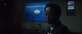 Movie still from “Suicide Squad” (2016), directed by David Ayer – A woman in front of a television in a room; Close Up shot, Low angle