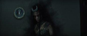 Movie still from “Suicide Squad” (2016), directed by David Ayer – A woman in a black outfit and a green and red headband; Close Up shot, High angle